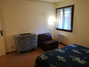 - une chambre avec un lit, une chaise et une fenêtre dans l'établissement Appartement T2 Ax-les-thermes, à Ax-les-Thermes