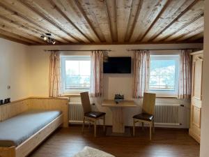 a bedroom with a bed and a table and chairs at Pöchtlhof in Leogang