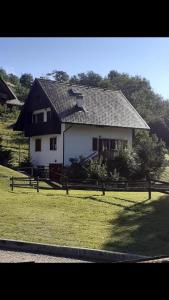 uma casa branca com um telhado preto num campo em Casa vacanze Ravascletto em Ravascletto