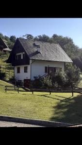 ein weißes Haus mit schwarzem Dach auf einem Feld in der Unterkunft Casa vacanze Ravascletto in Ravascletto