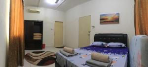 ein Schlafzimmer mit einem Bett und zwei Stühlen darin in der Unterkunft Homestay Din’s in Semporna