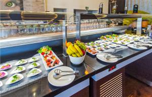 a buffet line with plates of food and fruit at Eden in Binz