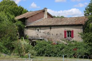 an old house with a red window and a fence at Les Chenevières in Culey