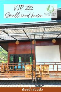 a small wood house with wooden chairs and a sign at สะปัน กลางนา คาเฟ่ Sapan Klang Na Cafe in Ban Huai Ti