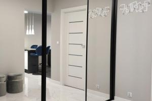 a mirrored closet with a blue chair in a room at Nowoczesny apartament w pobliżu centrum in Kraków