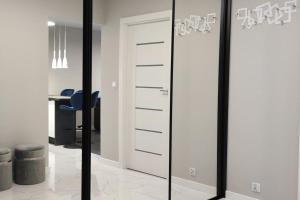 クラクフにあるNowoczesny apartament w pobliżu centrumの部屋にある青い椅子と鏡付きのクローゼット