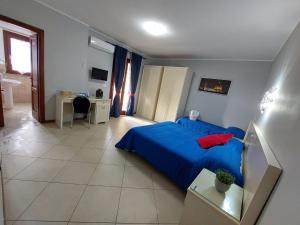 sypialnia z niebieskim łóżkiem i biurkiem w obiekcie Fiumicino Inn Airport w mieście Fiumicino