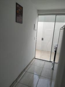 a bathroom with a glass door and a tile floor at Loft/APTO em Praia da Pinheira in Pinheiro