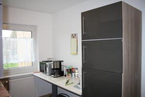 a kitchen with a black refrigerator next to a table at Chiaras Ferienwohnung in Heusweiler