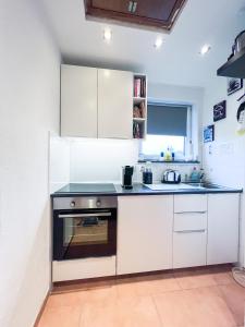 a kitchen with white cabinets and a stove at Ferienwohnung Miraflor in Solingen
