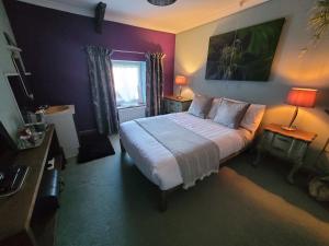 a bedroom with a bed and two lamps and a window at Farmhouse B&B Family stay or Romantic break, on our smallholding close to Narberth in Narberth