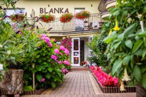 a flower shop with flowers in front of a building at Blanka in Rowy