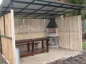 a picnic table and a pizza oven under a tent at Tiny house Floare de colt in Moieciu de Sus