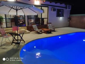 a swimming pool with a table and chairs and an umbrella at Casa Quinta in Puerto Rico