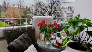 a table with a plate of food and flowers on a balcony at Mikołowski Sen in Mikołów