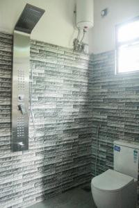 ein Bad mit einem WC und einer Ziegelwand in der Unterkunft Villa Freiheit Himmel in Bentota