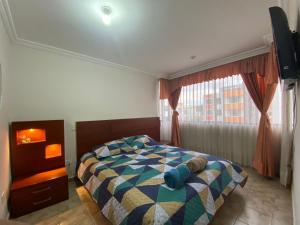 1 dormitorio con cama y ventana en Arriendo casa de dos pisos, en Quito