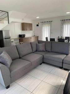 ein Wohnzimmer mit einem Sofa und einer Küche in der Unterkunft Lovely 2-bedrooms vacation villa with 3 pools in Grand-Gaube