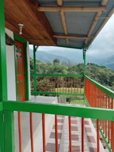 een uitzicht vanaf het balkon van een huis met een rode deur bij Hostal Bamboo in Salento