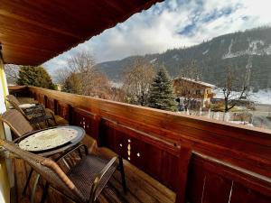 a balcony with a table and chairs and a view at Haus am Bach in Wagrain