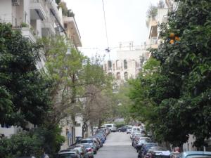 a city street with cars parked on the side of the road at acropolis super cosy apartment in Athens