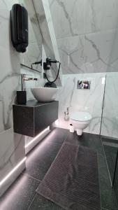 ein weißes Bad mit einem Waschbecken und einem WC in der Unterkunft Casa Chiper - Attic apartment with view in Braşov