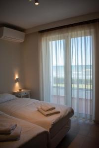 a bedroom with a bed and a large window at Greek Villas Justine View Beach in Kyllini
