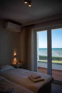 a bedroom with a bed and a view of the ocean at Greek Villas Justine View Beach in Kyllini