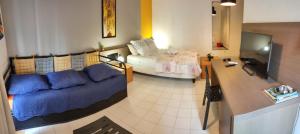 uma sala de estar com um sofá e uma cama em Le Cosy - Studio spacieux, équipé, proche Plage & Piscine, au Manganao em Saint-François