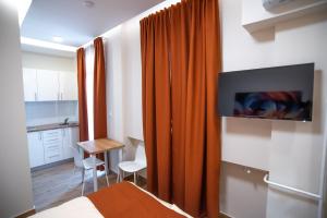 een slaapkamer met een oranje gordijn en een tv bij Premium Suites Terazije in Belgrado