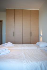 a large bed with white sheets and wooden cabinets at Greek Villas Justine View Beach in Kyllini