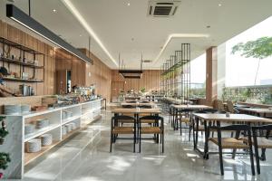 a restaurant with tables and chairs in a cafeteria at Cordela Suites Tasikmalaya in Tasikmalaya
