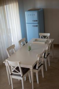 a white table and chairs with a refrigerator in a room at Greek Villas Justine View Beach in Kyllini