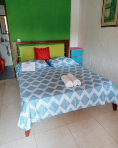 a bedroom with a bed with two towels on it at Hostal Bamboo in Salento