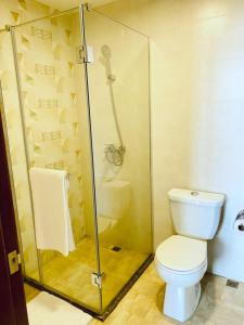 a bathroom with a toilet and a glass shower at Century Park Hotel & Residences in Kigali