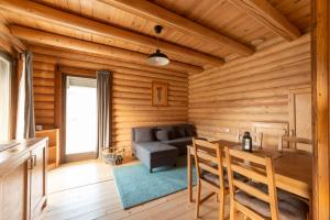 Cabaña de madera con sala de estar con sofá y mesa en Farkaskútvölgy, en Felsőtold