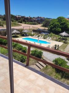 een balkon met uitzicht op een zwembad bij Hotel Aquarella in Punta Del Diablo