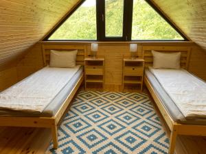 two beds in a room with two windows at Farkaskútvölgy in Felsőtold