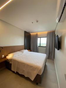 a bedroom with a large bed and a window at Salinas Premiun Resort Vista Mar ap1604 in Salinópolis