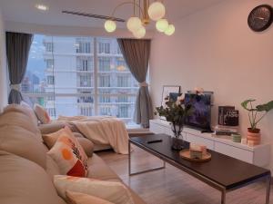 a living room with a couch and a table at LUX SUITES KL City Pavilion Bukit Bintang with INFINITY POOL in Kuala Lumpur
