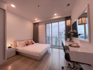 a bedroom with a bed and a desk and windows at LUX SUITES KL City Pavilion Bukit Bintang with INFINITY POOL in Kuala Lumpur