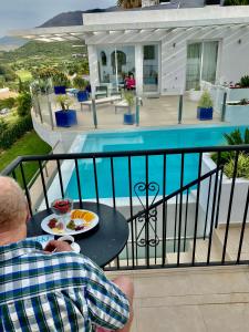 un hombre sentado en un balcón con un plato de comida en Villa Hesla, en Estepona
