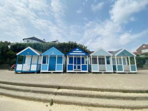 a row of blue beach huts on the beach at Cottage Number 5 in Southwold - Charming cottage gardens in Southwold