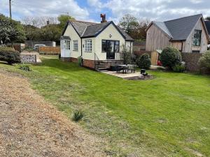 a house with a picnic table in a yard at Cottage Number 5 in Southwold - Charming cottage gardens in Southwold