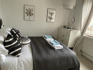 1 dormitorio con 1 cama con 2 toallas en Cottage Number 5 in Southwold - Charming cottage gardens, en Southwold