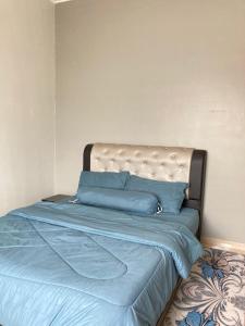 a bed with blue sheets and pillows in a bedroom at D’Anom Homestay in Kluang