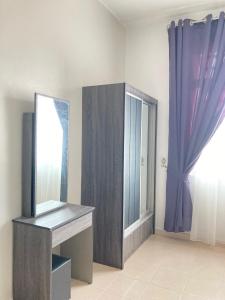 a bathroom with a vanity and a mirror and a window at D’Anom Homestay in Kluang