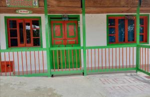 ein Gebäude mit grünen und roten Türen und Fenstern in der Unterkunft Hostal Bamboo in Salento