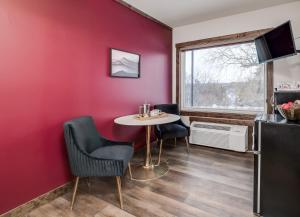 Cette chambre comprend une table, des chaises et un mur rouge. dans l'établissement The Harbor Hotel Chic, Retro Hotel, à Prescott