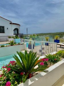 a house with a swimming pool with a fence and flowers at Villa Hesla in Estepona
